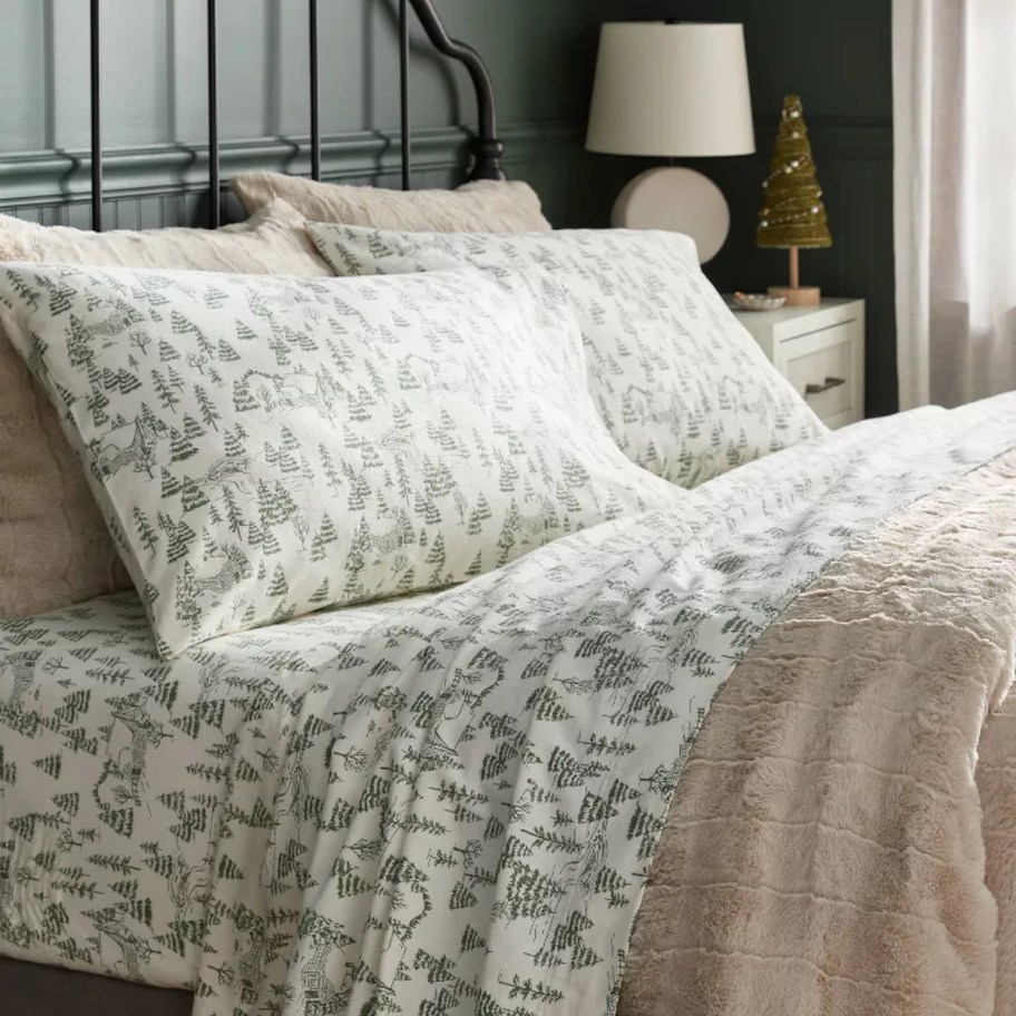 bed with white and green tree sheets 