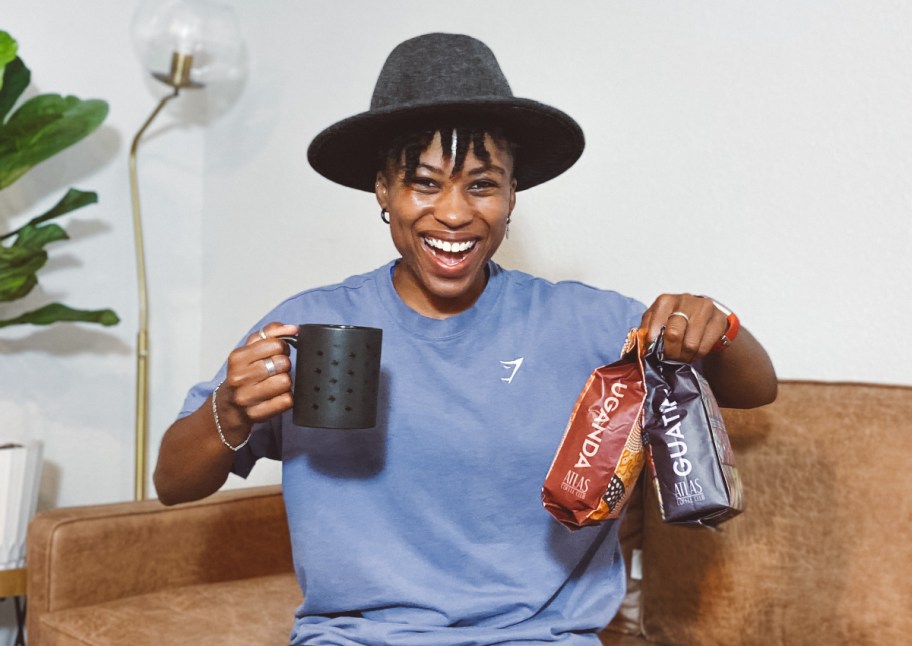 woman holding bags of coffee and mug