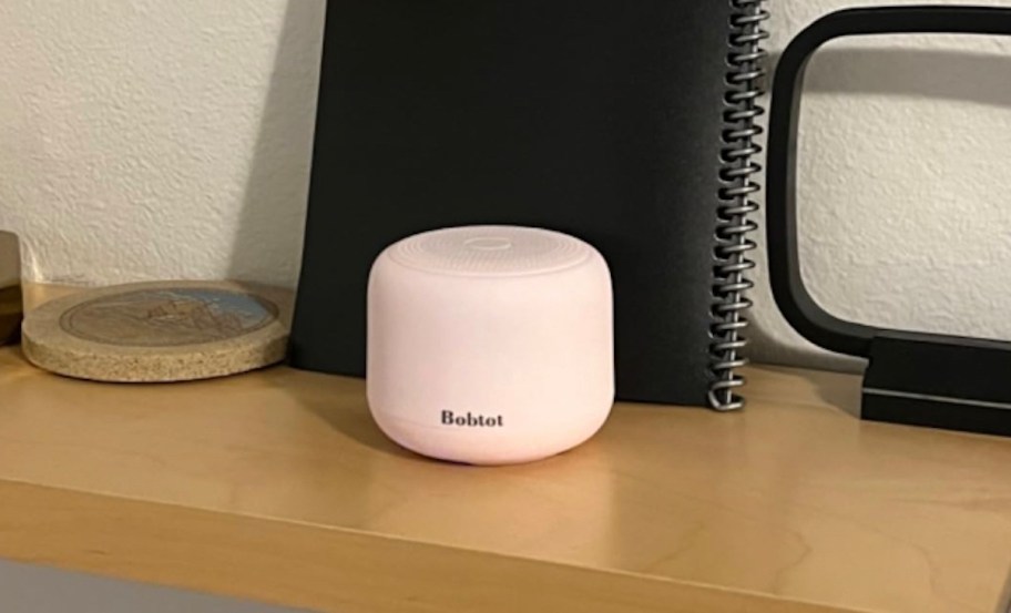 small light pink portable speaker on desk