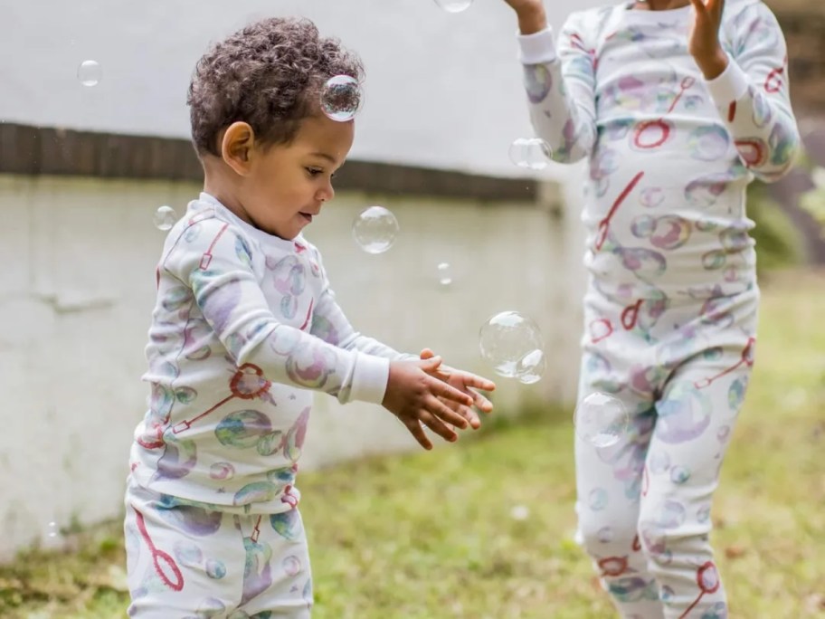 kids playing with bubbles outside wearing matching long sleeve pajama sets with bubbles on them