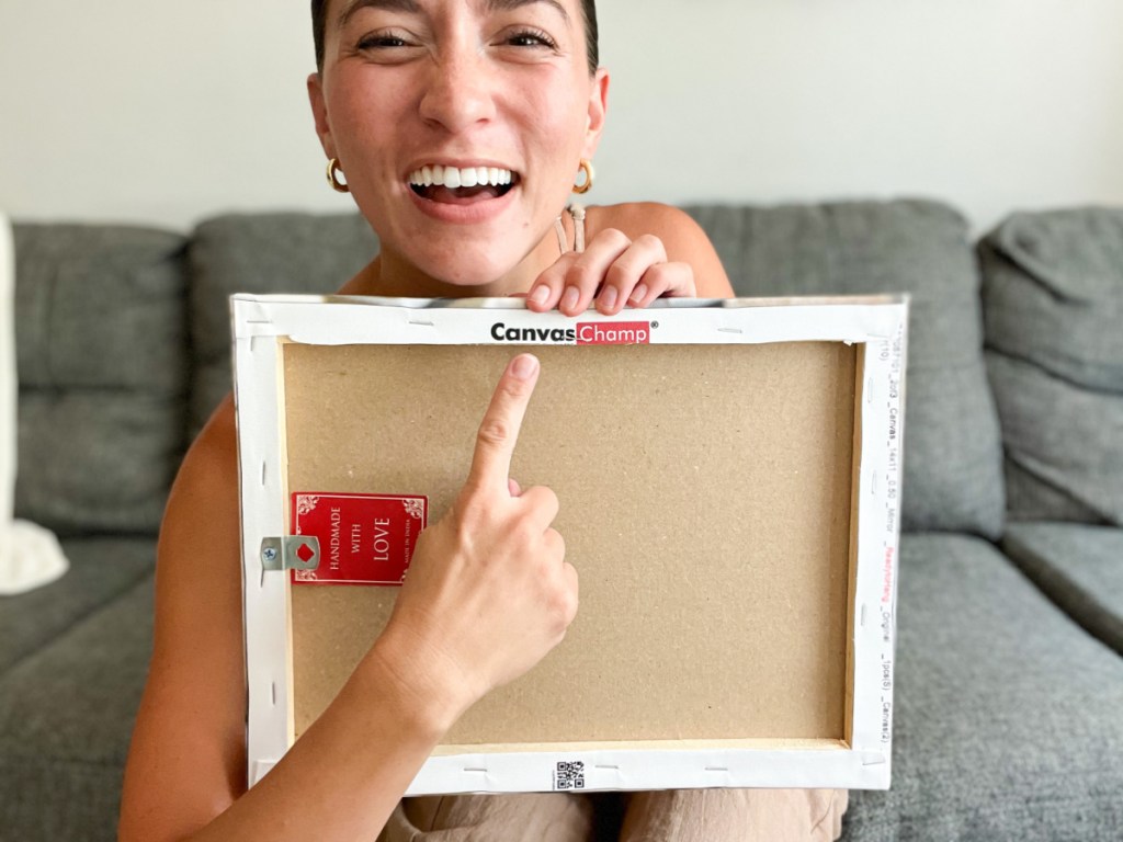 woman pointing to back of canvas