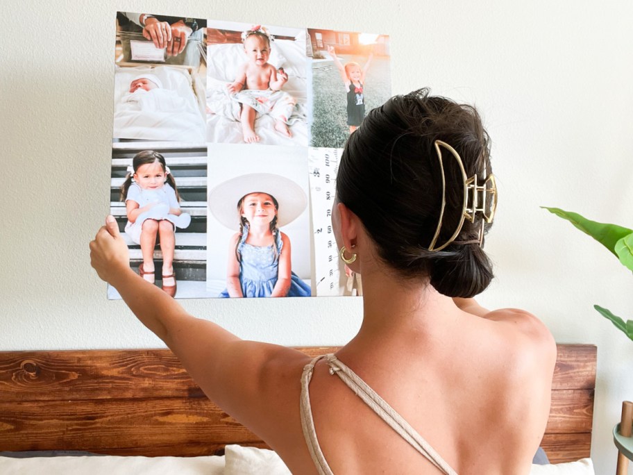 woman hanging canvas on wall