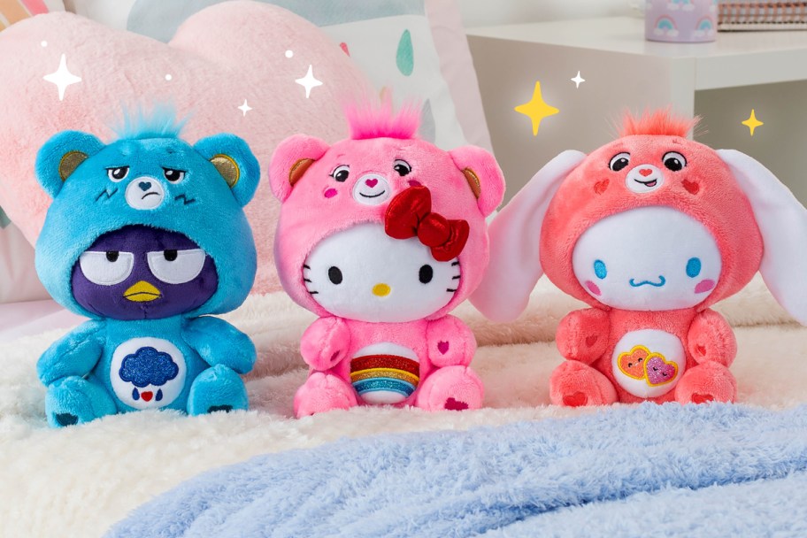 three Hello Kitty plush characters dressed as Care Bears