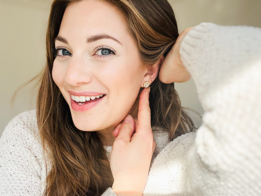 woman pointing to stud earrings