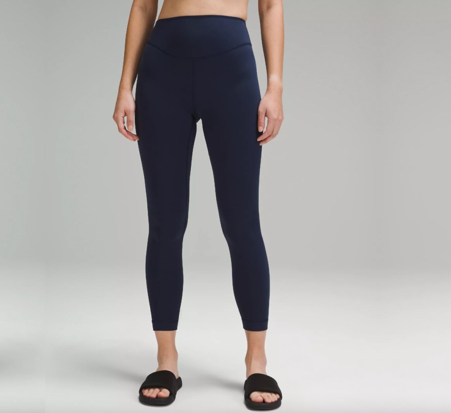 woman in navy blue leggings and slides