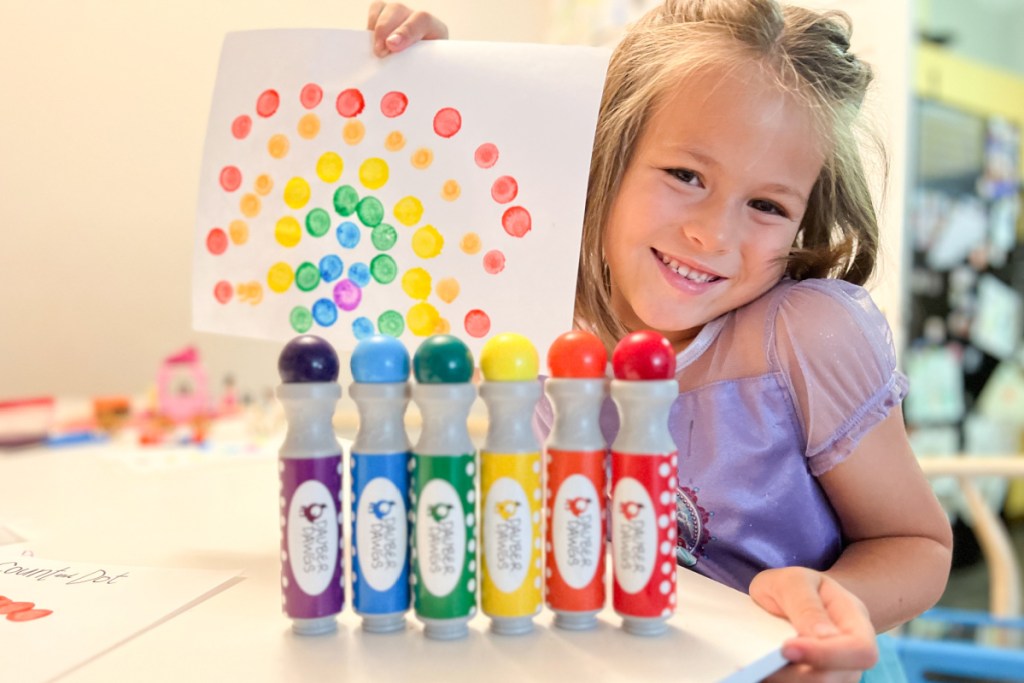 girl holding up dot marker picture