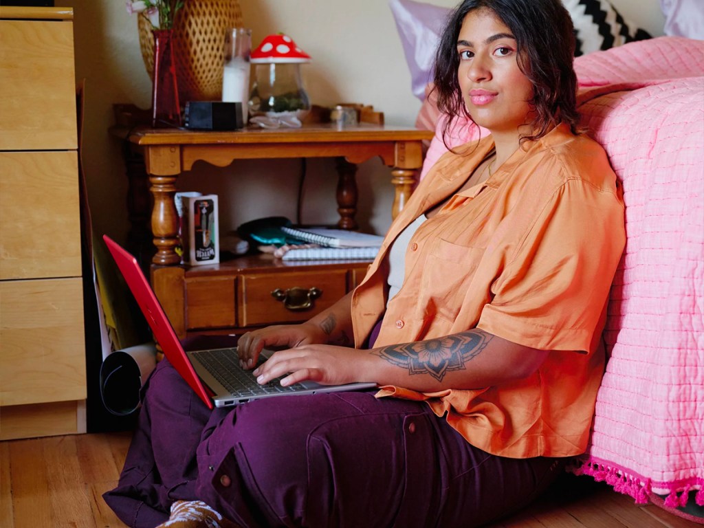 woman using hp laptop on floor