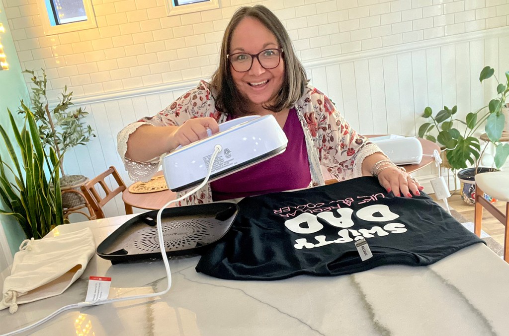 woman holding heat press over tshirt