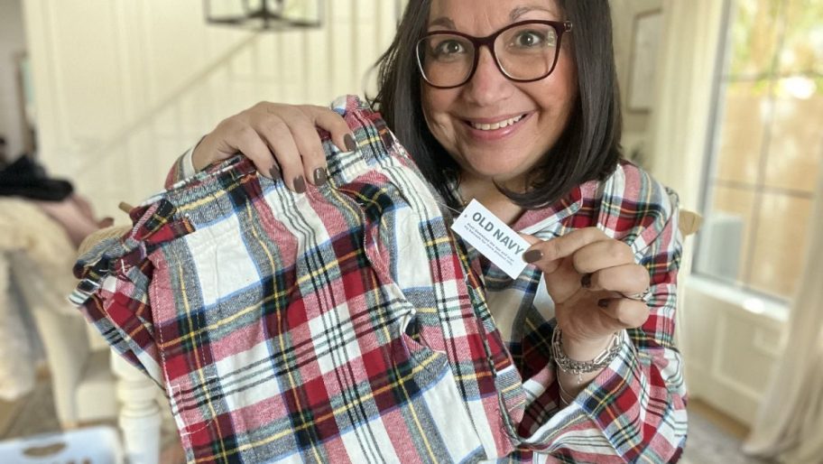 a woman in plaid pjs holding a pair of plaid pajama pants