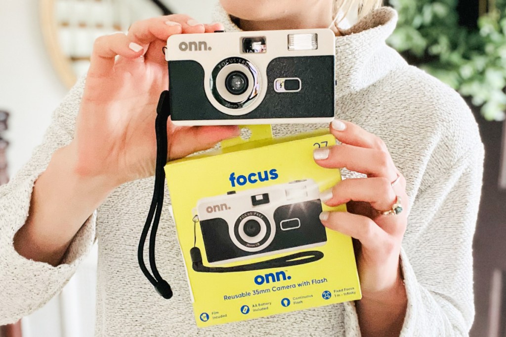 woman holding camera and box