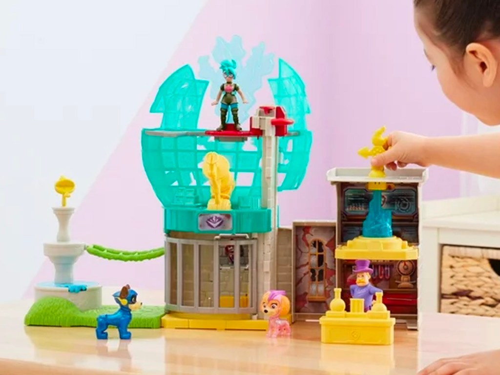 girl playing with paw patrol toy on table