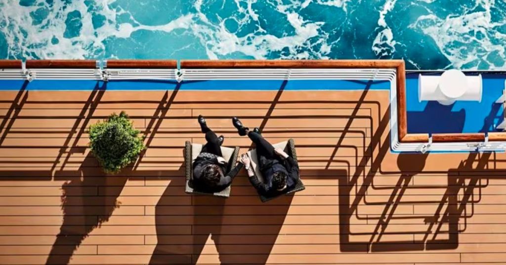 a couple sitting in chairs on the deck of a princess cruise ship