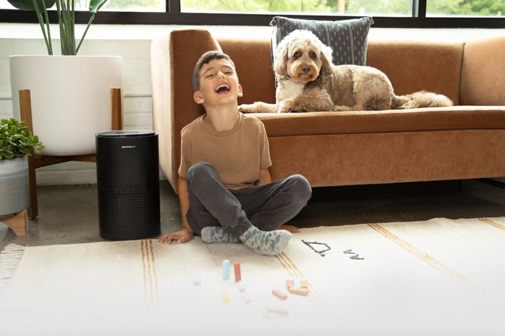 boy and dog sitting next to air filter