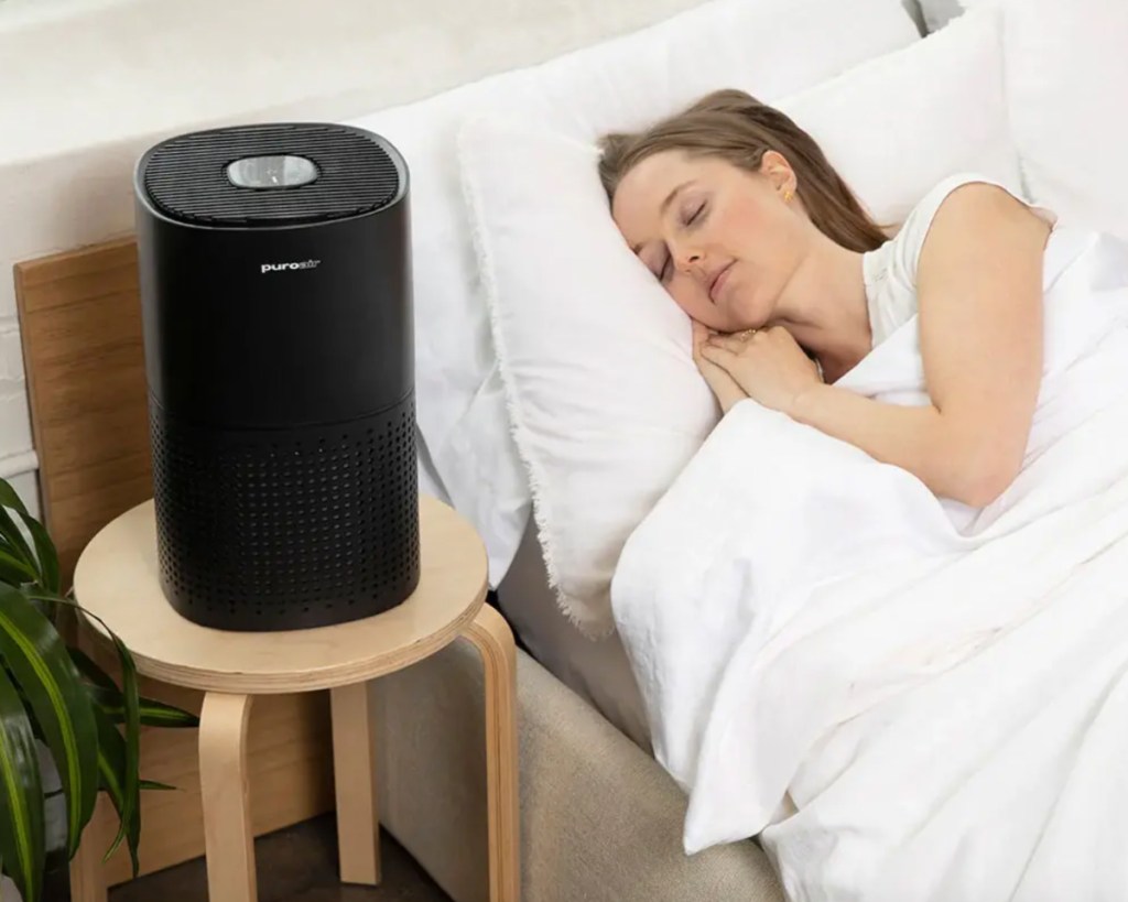 woman sleeping next to air purifier