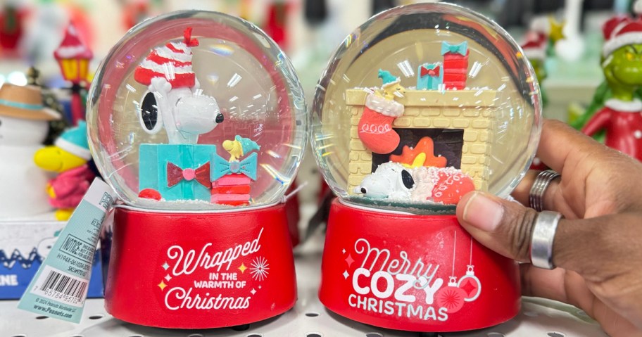 two snoopy snowglobes on shelf