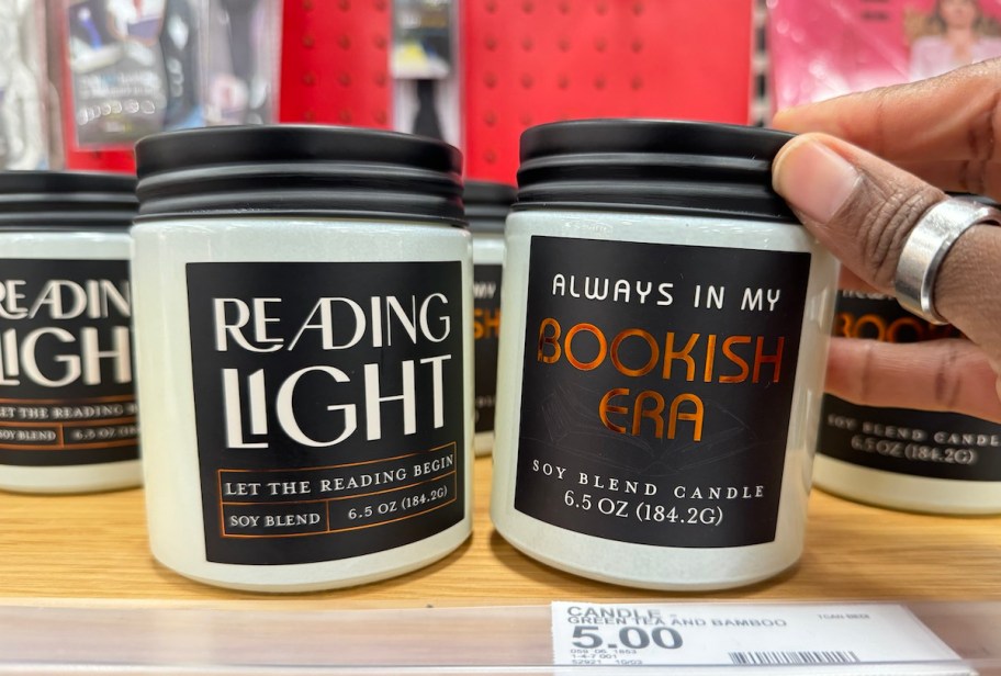 hand holding top of bookish era candle on store shelf