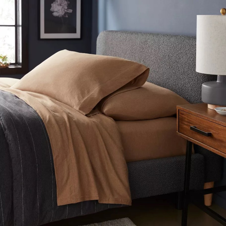 dark bedroom with camel brown sheets and pillows