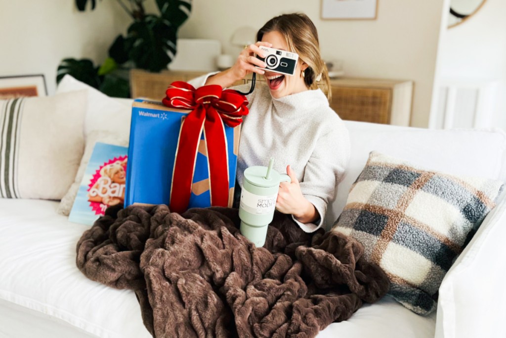 woman sitting with camera on face and walmart box