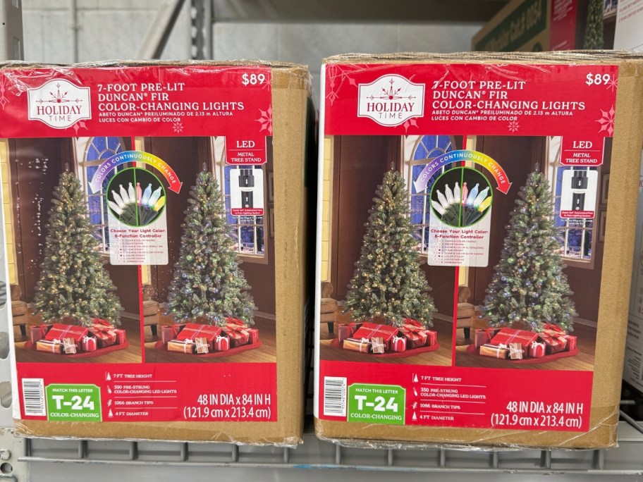 2 large Christmas tress in boxes on a store shelf