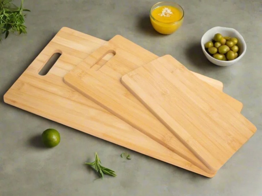 three bamboo wood cutting boards on a counter with food arou9nd them