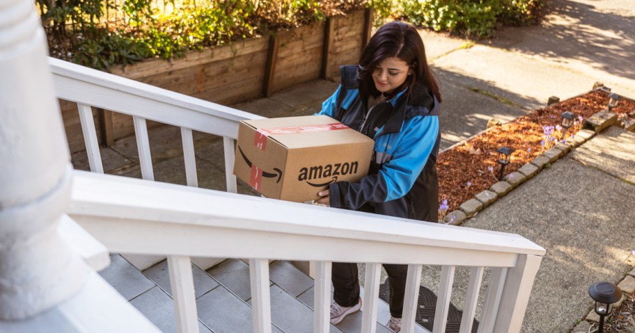 Amazon delivery driver walking amazon box up porch steps