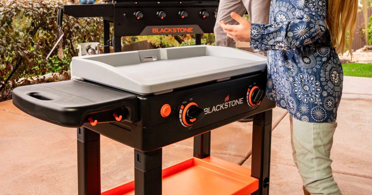 little girl standing in front of a blackstone griddle toy