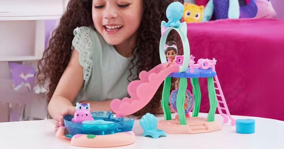 girl playing with Gabby's Dollhouse Purr-ific Pool Playset w/ Gabby & MerCat Figures