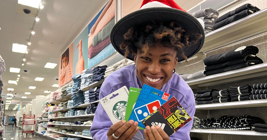 woman holding up a variety of gift cards