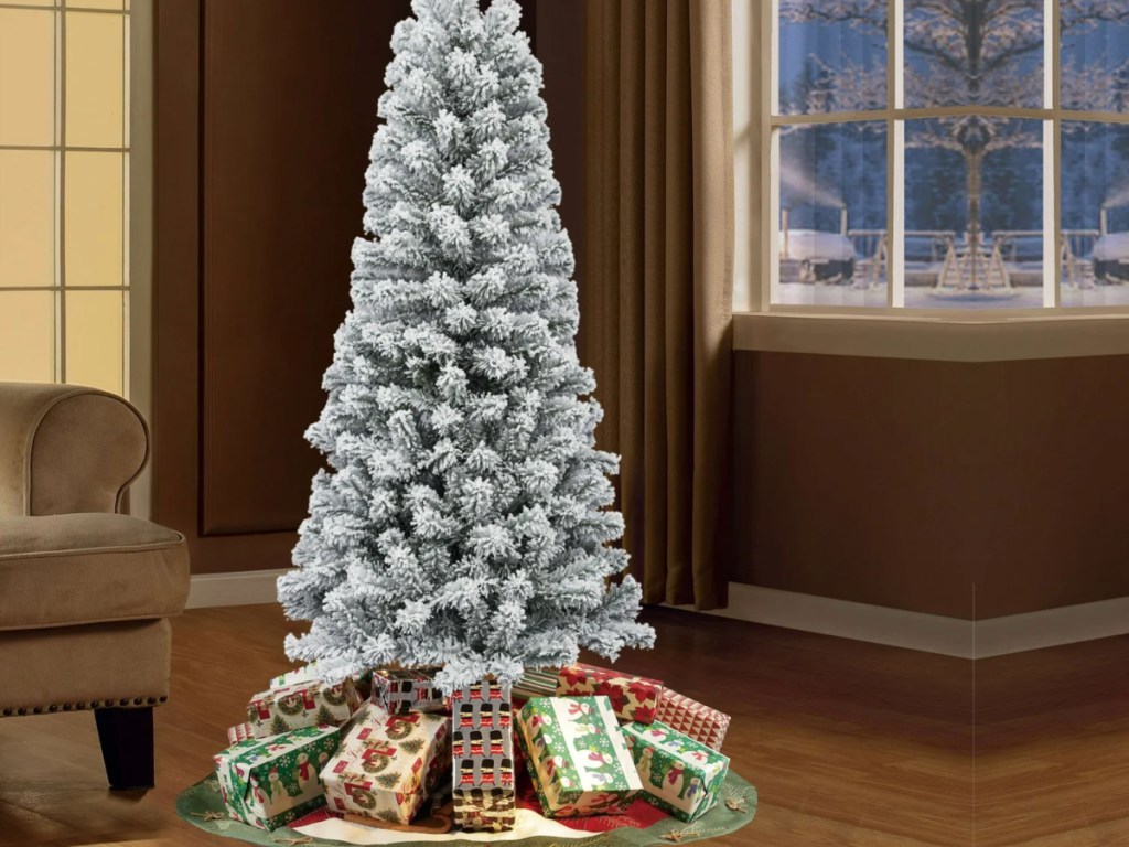 flocked artificial christmas tree in room next to window