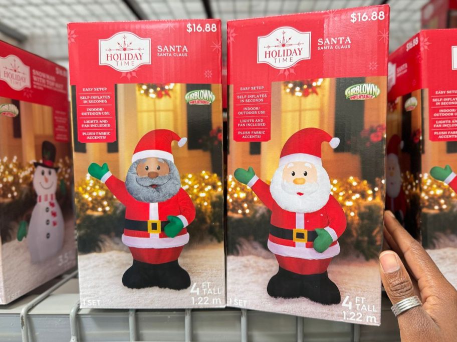 two Holiday Time Inflatable Santa Clauses on shelf in store