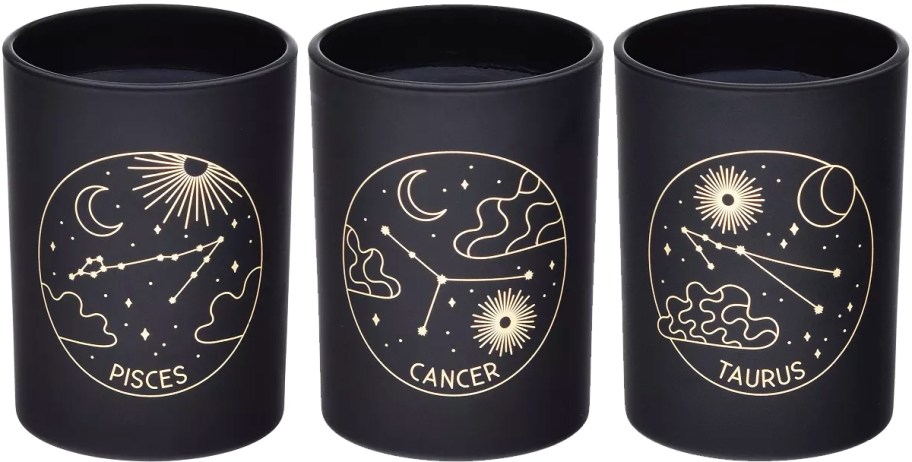 three black and gold candles with zodiac star signs