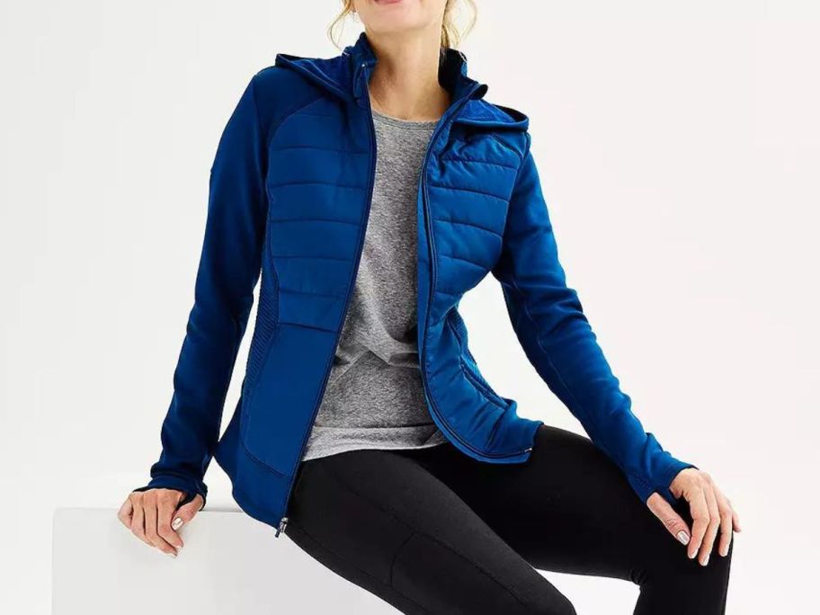 A woman wearing a Tek Gear Hooded Mixed-Media Jacket in blue