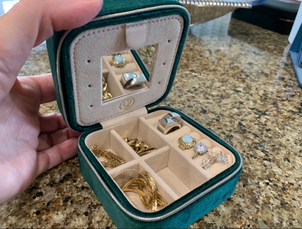 Close-up of blue velvet jewelry, travel, case on the kitchen counter, filled with jewelry pieces