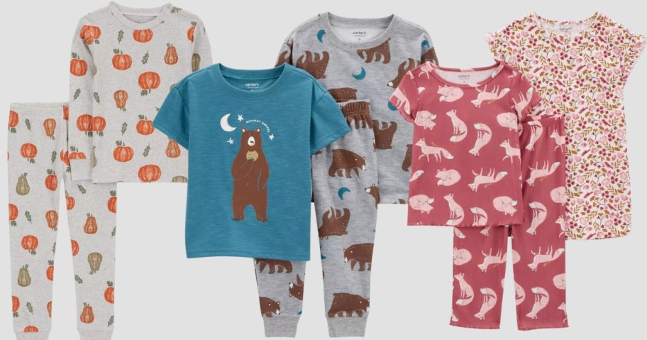 baby and toddler pajama sets, one grey with pumpkins, one blue and grey with bears, and one pink with floral and feathers