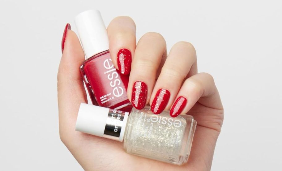 woman with painted nails holding the red essie 2 piece nail color gift set