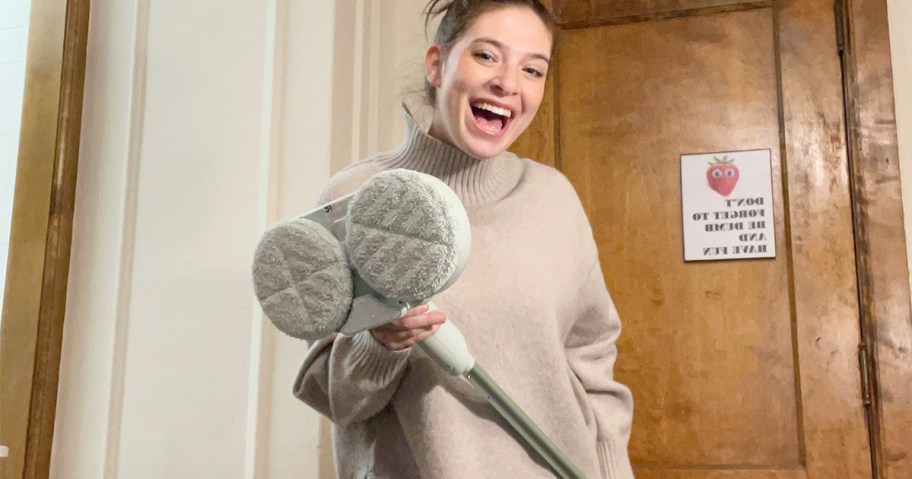 woman in long sleeve tee holding green hover mop