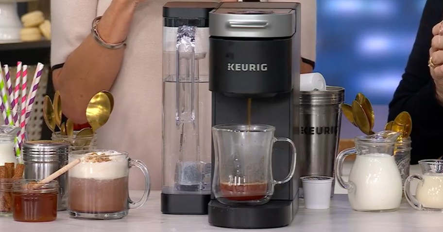 black keurig coffee maker pouring coffee into coffee mug