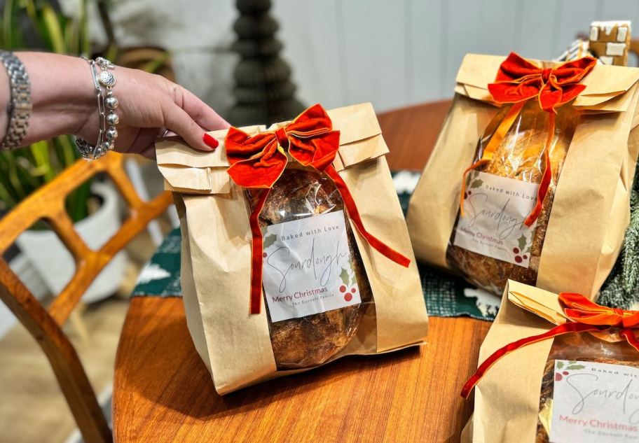 hand holding a bag with sourdough bread inside