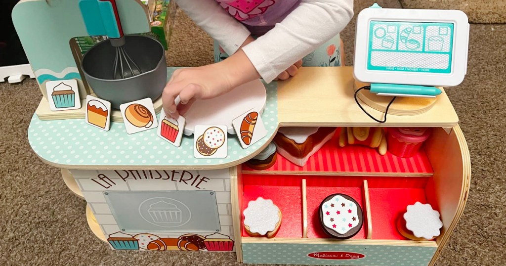 girl playing with bakery playset