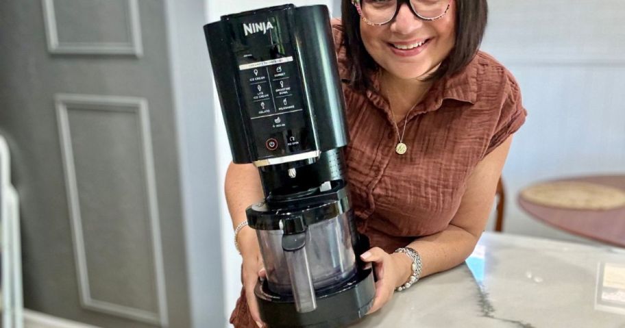 ninja creami being held by woman on kitchen counter