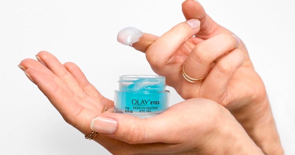 hand holding olay deep hydrating gel jar with finger holding gel on it