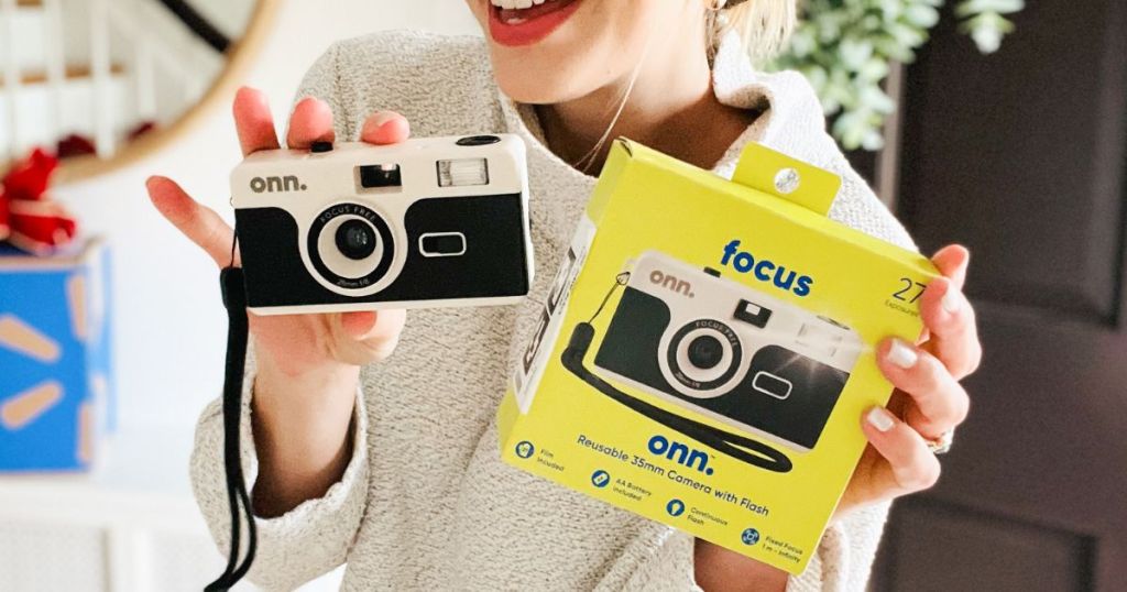 A woman holding a onn. Reusable 35mm Camera with Flash