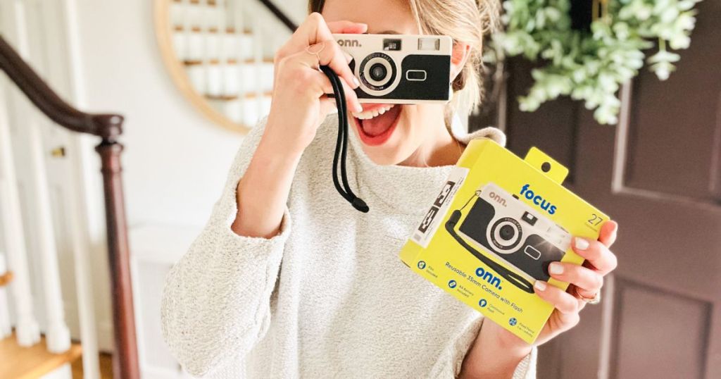 A woman holding a onn. Reusable 35mm Camera with Flash