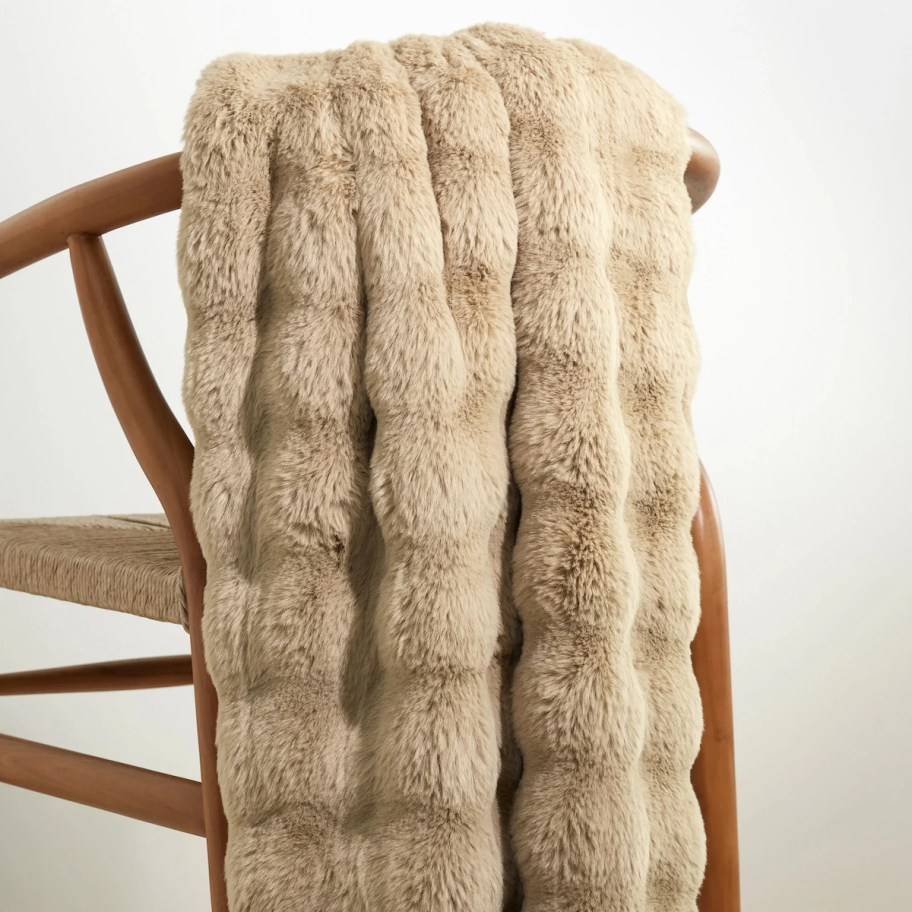 brown faux fur throw draped over wooden chair