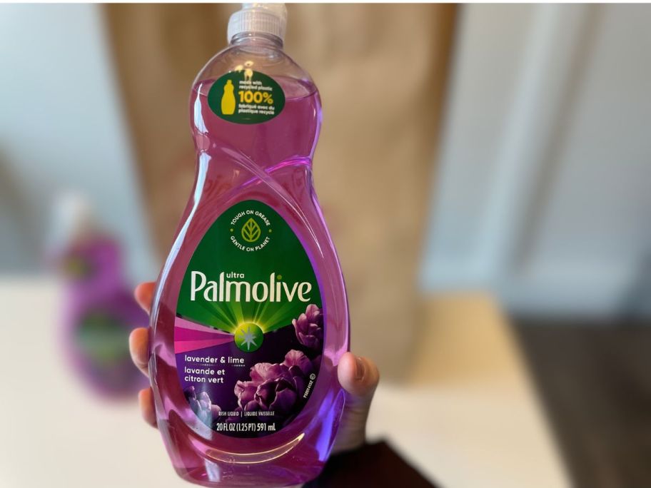 hand holding a purple bottle of palmolive dish soap