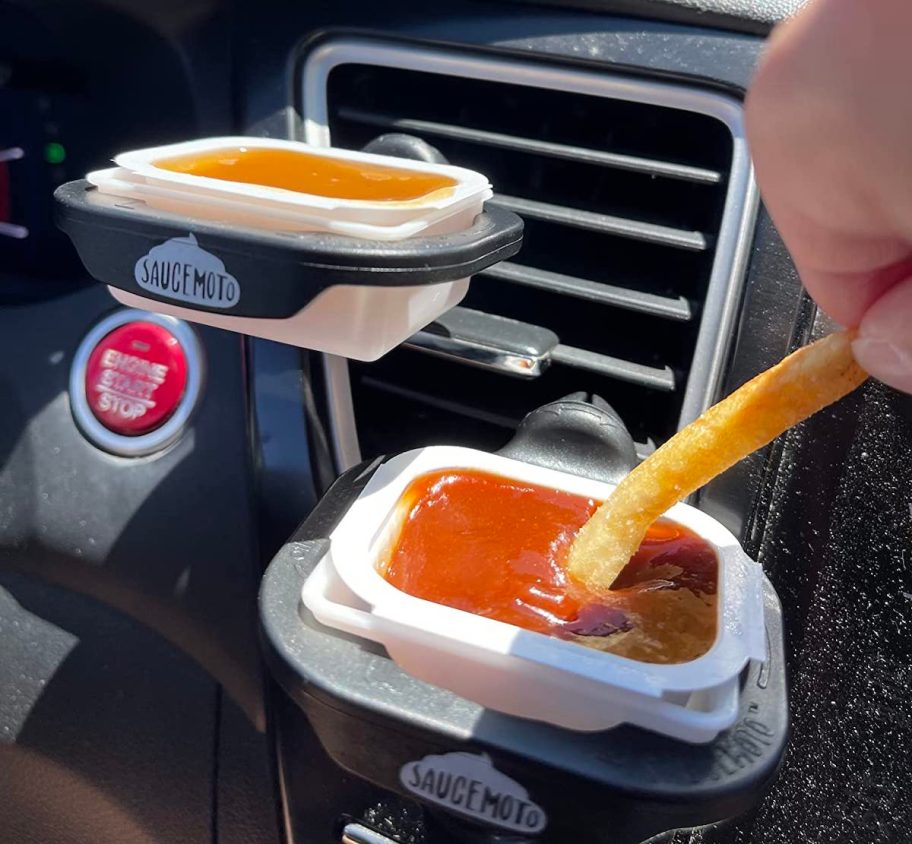 hand dipping french fry into saucemoto dip clip in car