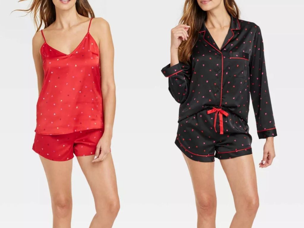 woman wearing a red polka dot satin pajama shorts and cami set and woman wearing a black with red hearts long sleeve and shorts satin pajama set