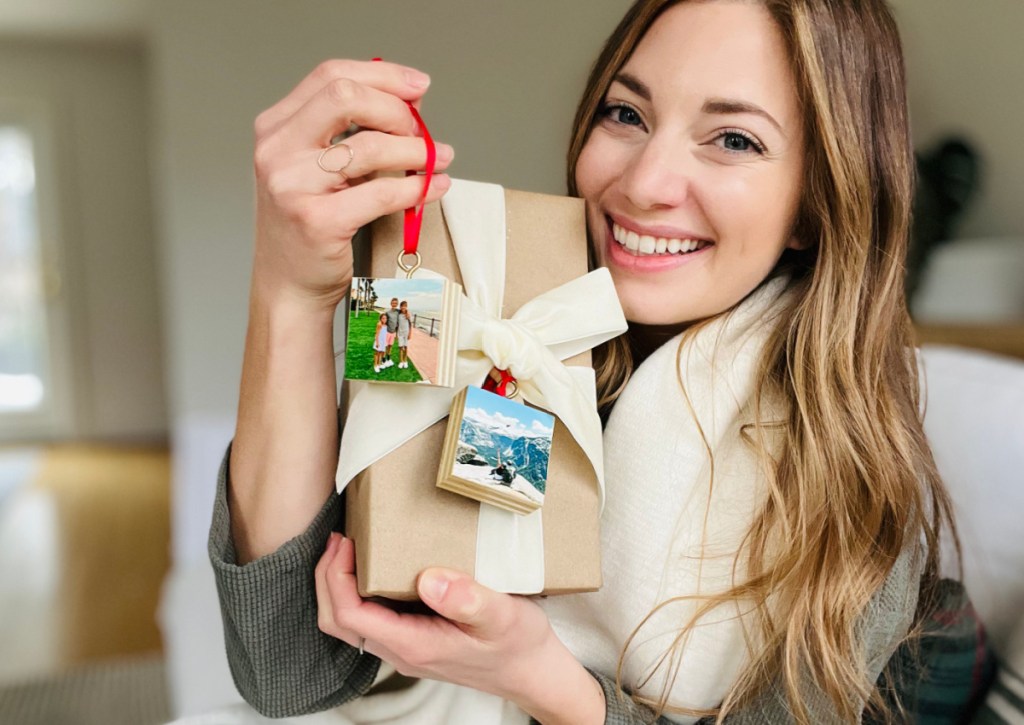 woman holding gift with two photo ornaments attached