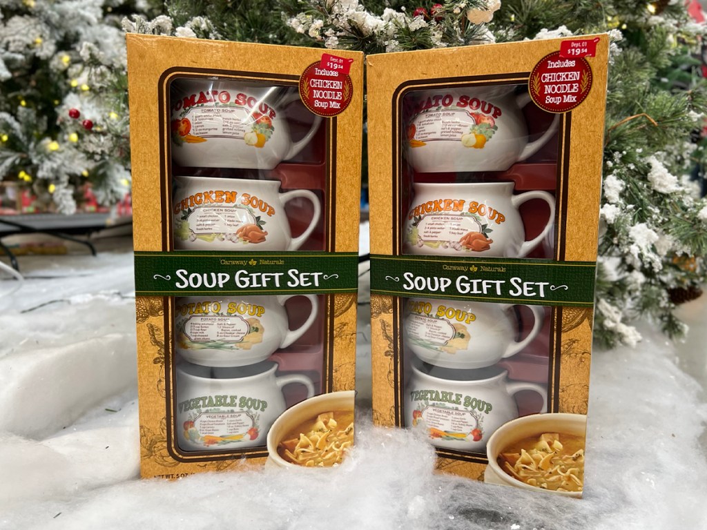 two soup gift set boxes sitting in front of christmas trees