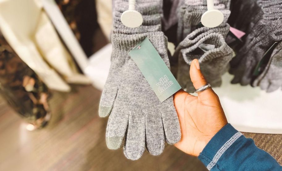 a woman's hand displaying a pair of gray knit women's gloves